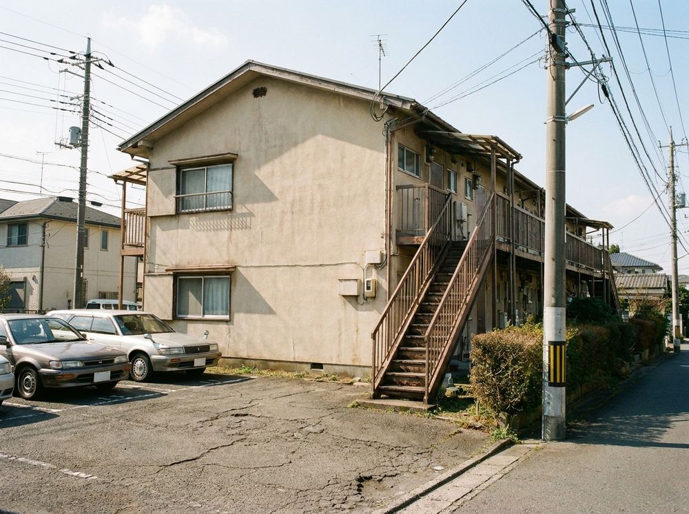 コーポ和田の外観。外階段のある2階建てのアパートと、目の前の駐車場